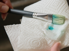 Kläm med papper runt penseln för att kontrollera att den är ren och för att ta bort överflöd av vatten | DinAtelje.se